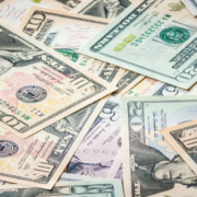 Scattered American five-dollar, ten-dollar, and twenty-dollar bills overlapping in a disorderly arrangement