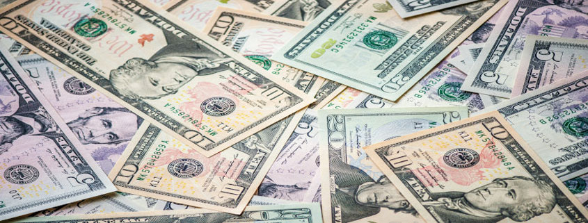 US-Dollar-Bills-Scattered-in-Overlapping-Piles Scattered American five-dollar, ten-dollar, and twenty-dollar bills overlapping in a disorderly arrangement