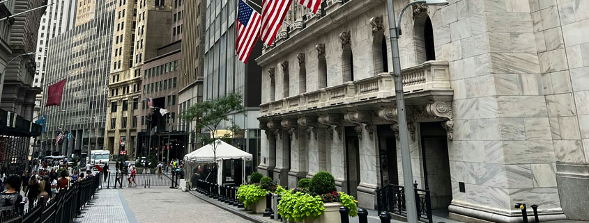 Wall Street financial district in New York City with American flags displayed among the buildings