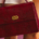 Fashion handbag hanging beside a woman's legs, with the lower portion of her skirt visible as she stands