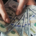 Woman's hands holding and spreading several US hundred-dollar bills in a fan-shaped arrangement