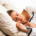 Woman lying in bed with her eyes closed, appearing to sleep peacefully