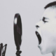 Young boy with his mouth wide open in front of a recording microphone, appearing to sing or shout