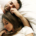 Young couple sharing a kiss and affectionate embrace while waking up together in bed in the morning